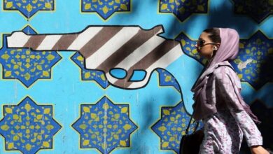 استراتيجية نظام الولي الفقيه بين أزمة غزة والأزمات الداخلية فتاة تمر أمام جدار المقر السابق للسفارة الأميركية في طهران